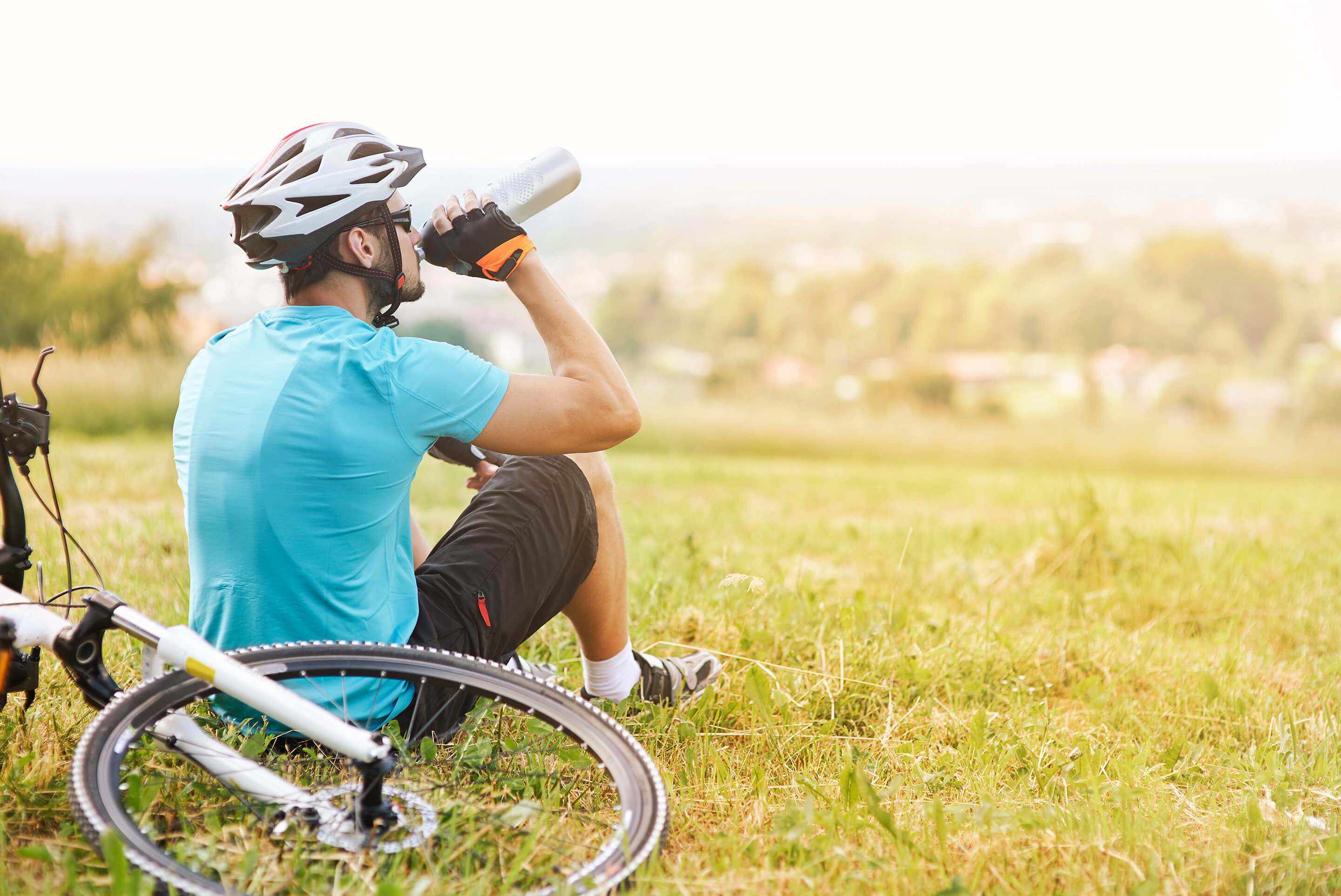 homme buvant sa gourde près de son vélo