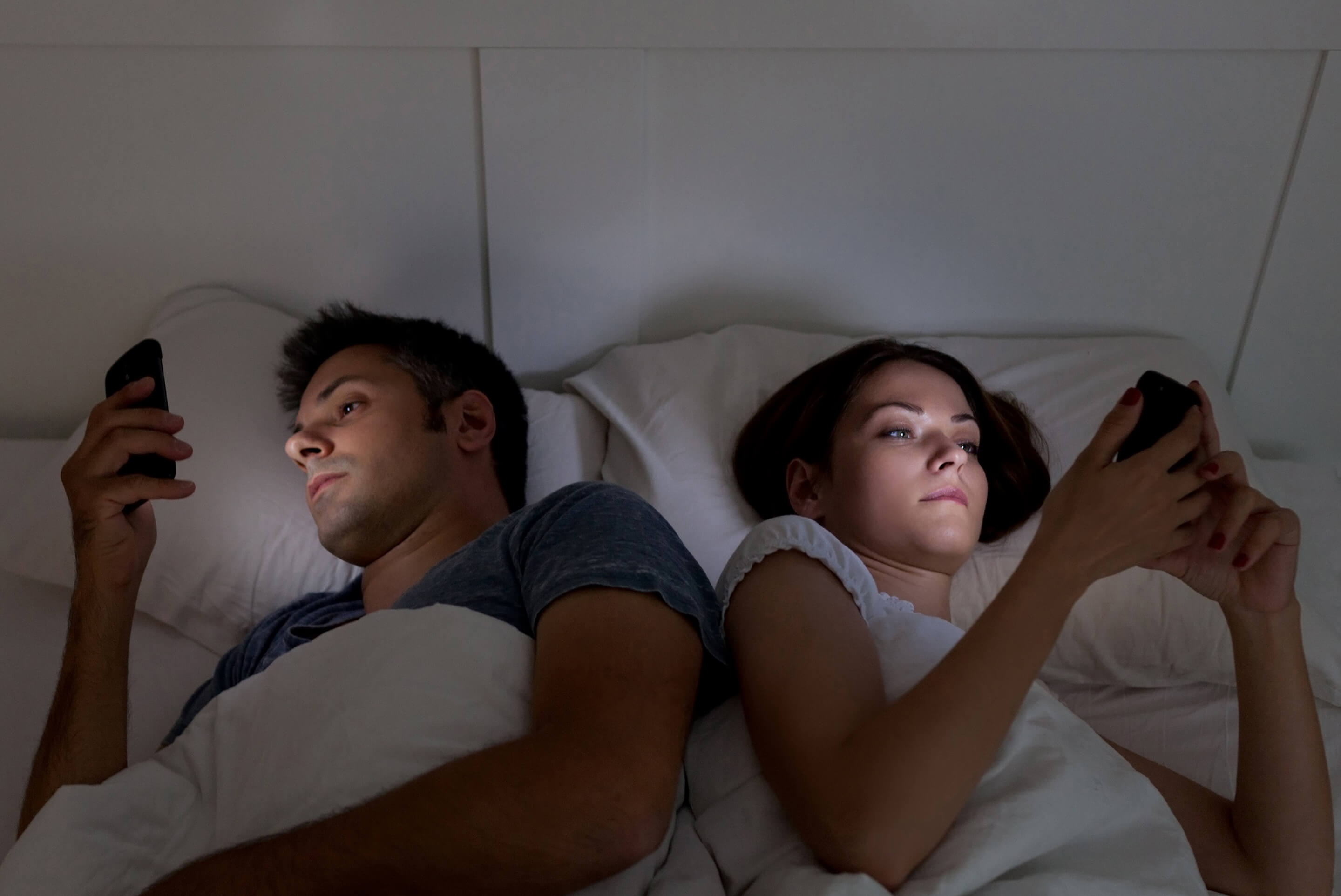 couple au lit avec leurs téléphones