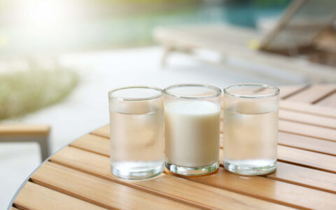 un verre de lait et deux verres d'eau sur une table