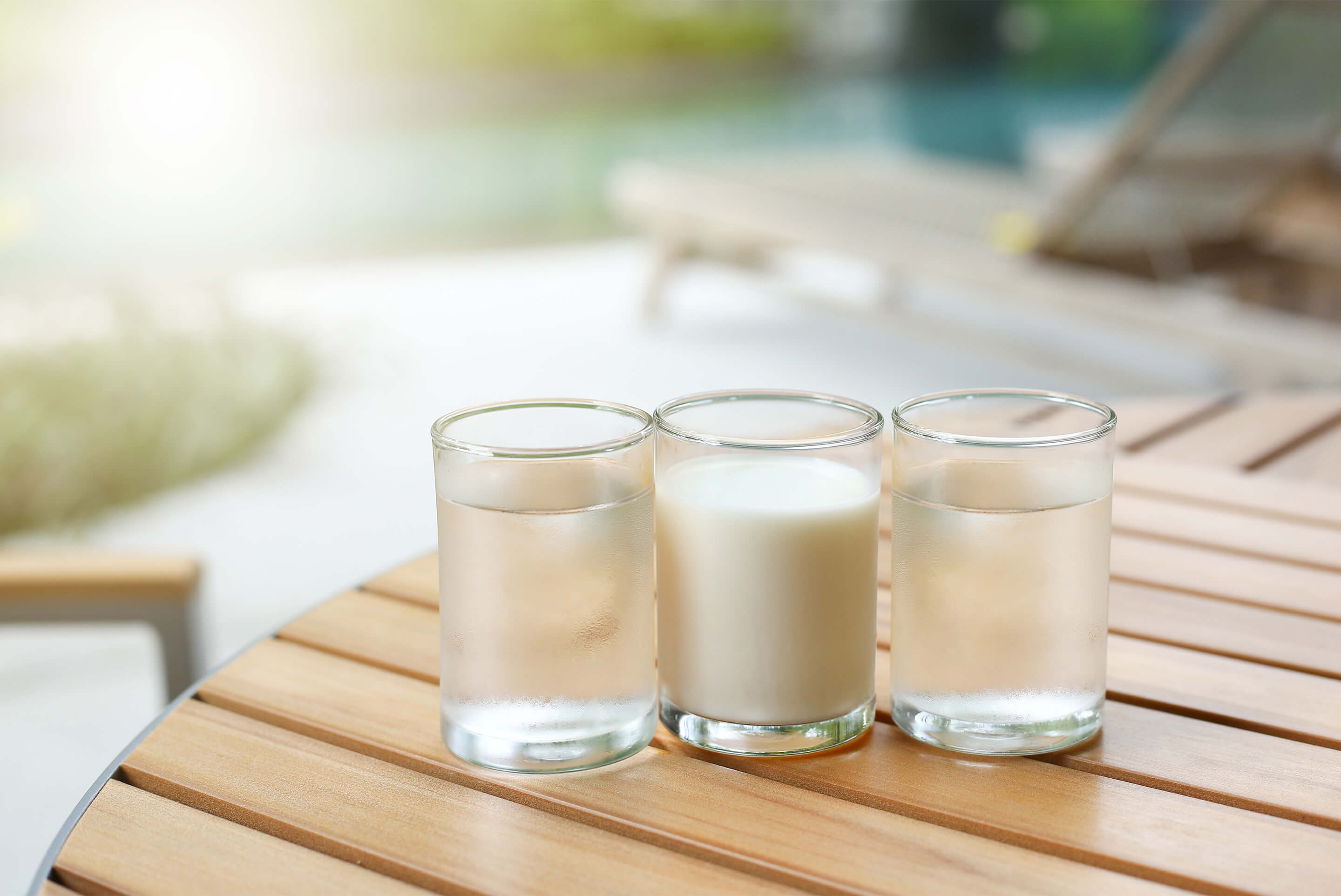 un verre de lait et deux verres d'eau sur une table