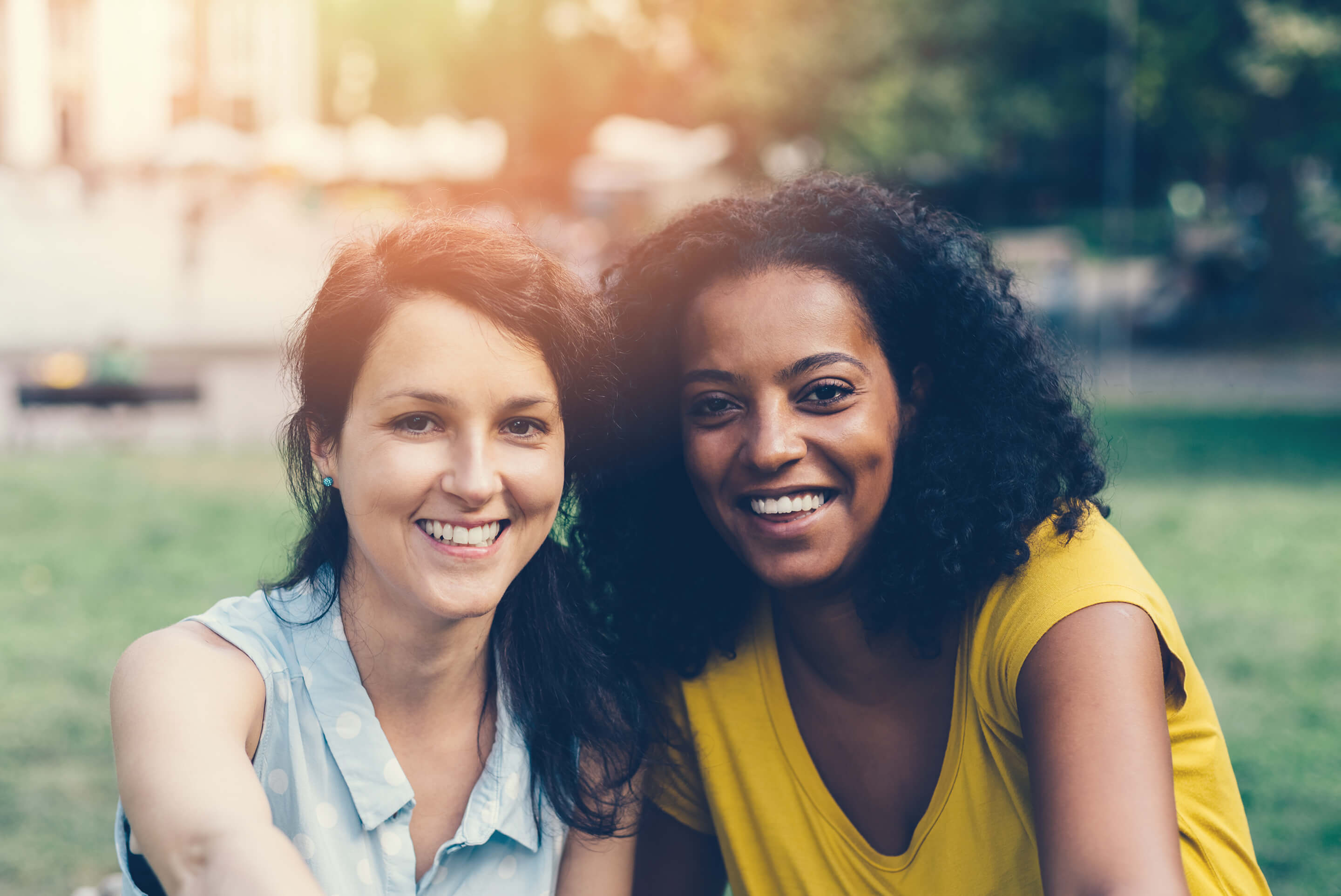 femmes souriantes assisent dans un parc