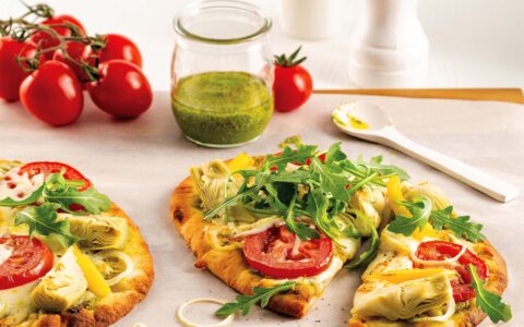 pizza roquette colorée sur pain naan et petit pot de pesto