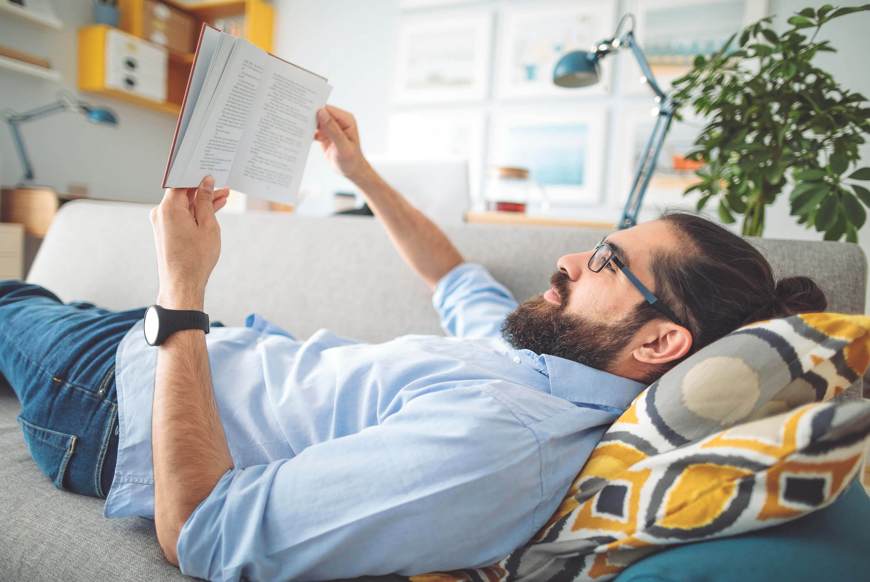 homme qui lit sur un canapé