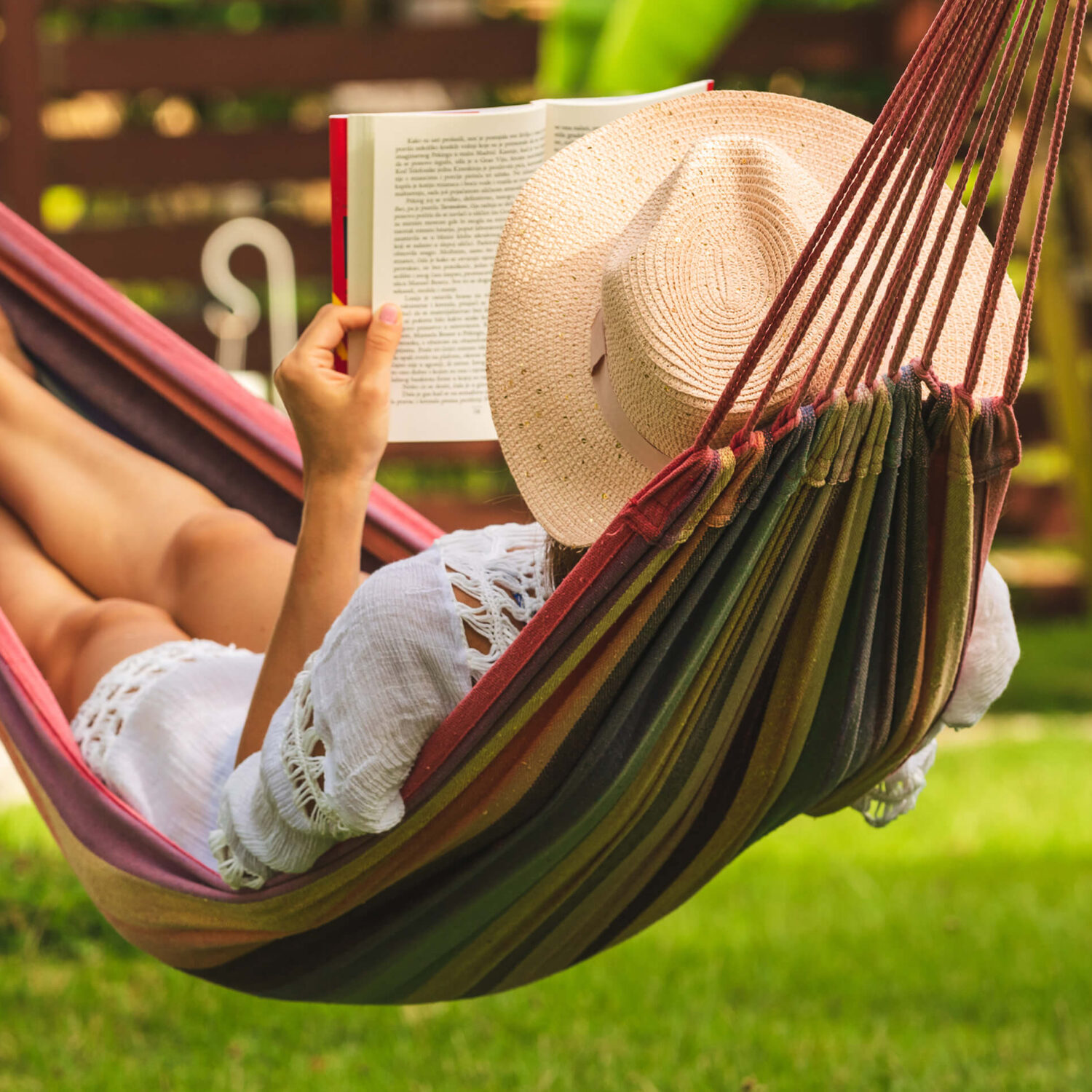 femme lisant un livre dans un hamac au soleil