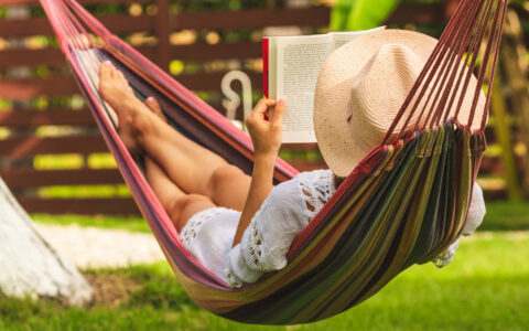 femme lisant un livre dans un hamac au soleil