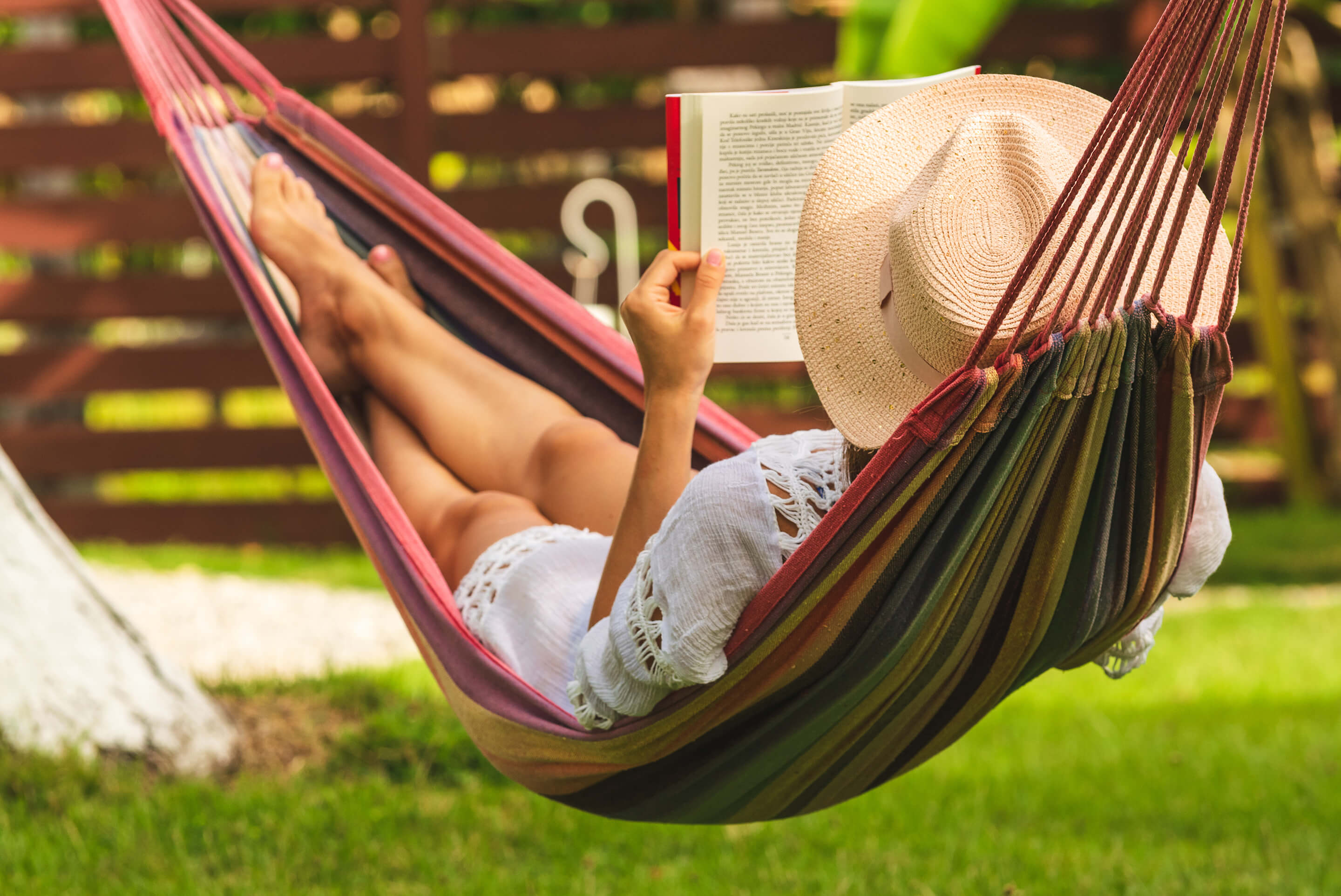 femme lisant un livre dans un hamac au soleil