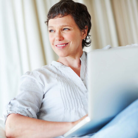 femme souriante qui travaille sur son ordinateur portable