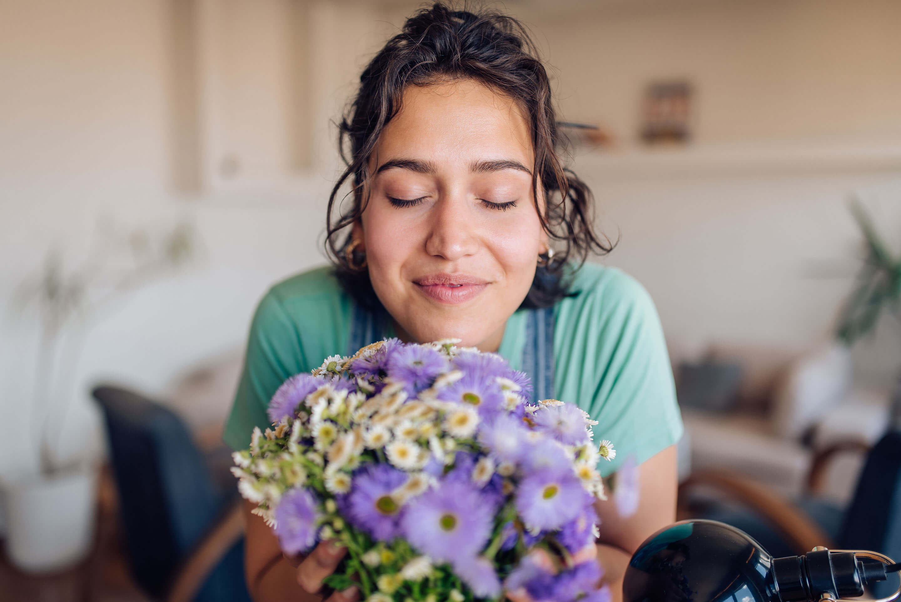 femme respirant un bouquet de fleurs