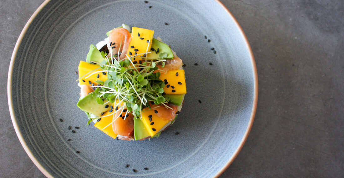 sushi cake au saumon mangue et avocat dans une assiette