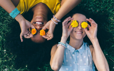 femmes dans l'herbe jouant avec des fleurs