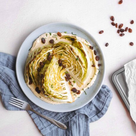 Quartiers de chou rôtis, hummus et raisins secs