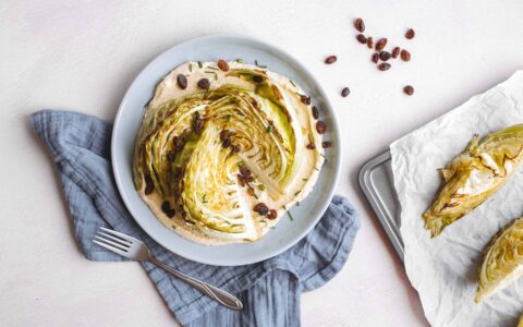 Quartiers de chou rôtis, hummus et raisins secs