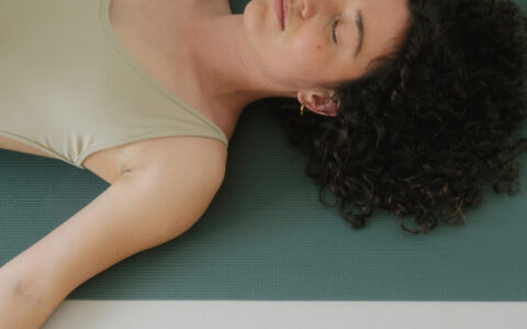 femme couchée sur un tapis de yoga